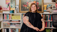 Woman smiling at camera with bookshelves behind her