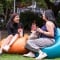 Two young people on beanbags mid-conversation and smiling